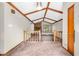 Sunlit living room featuring carpet, a vaulted ceiling, brick fireplace and large windows at 407 Woodland E Dr, Greenfield, IN 46140