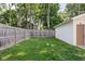 Large grassy backyard with a wood fence and a detached garage providing space for play and privacy at 4137 Rookwood Ave, Indianapolis, IN 46208