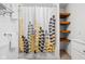 Bathroom with leaf shower curtain, open wooden shelving and a tiled floor at 4137 Rookwood Ave, Indianapolis, IN 46208