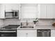 Kitchen with modern appliances, white cabinets, granite countertops, stainless steel sink, and a window with blinds at 4137 Rookwood Ave, Indianapolis, IN 46208