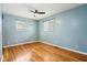 Light-filled bedroom with hardwood floors, ceiling fan, and two windows at 418 Dunbar Dr, Indianapolis, IN 46229