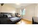 Bedroom with hardwood floors, a black bed, and a desk near the window at 430 Heritage Dr, Danville, IN 46122