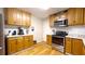 Kitchen featuring stainless steel appliances, oak cabinets, white subway tile backsplash, and hardwood floors at 430 Heritage Dr, Danville, IN 46122