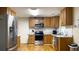 Kitchen featuring stainless steel appliances, oak cabinets, white subway tile backsplash, and hardwood floors at 430 Heritage Dr, Danville, IN 46122
