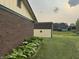 Backyard view featuring green lawn, landscaping, a storage shed and the side of the house at 4928 Dancer Dr, Indianapolis, IN 46237