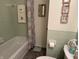 Charming bathroom with vintage green tile, tub and shower, and decorative accents at 4928 Dancer Dr, Indianapolis, IN 46237