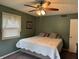 Relaxing bedroom with a ceiling fan, green walls, neutral decor, and cozy bed at 4928 Dancer Dr, Indianapolis, IN 46237