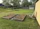 Backyard view featuring raised garden beds, a wooden chair, and a partial view of a storage shed at 4928 Dancer Dr, Indianapolis, IN 46237