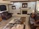 Cozy living room with brick fireplace, leather furniture, and neutral toned tile flooring at 4928 Dancer Dr, Indianapolis, IN 46237