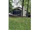 Scenic backyard view with a cozy hammock, mature trees and screened-in porch at 5010 Melbourne Rd, Indianapolis, IN 46228
