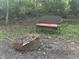 A fire pit and outdoor seating in the wooded backyard at 5010 Melbourne Rd, Indianapolis, IN 46228