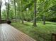 Inviting view of the backyard from the deck; features mature trees and relaxing space at 5010 Melbourne Rd, Indianapolis, IN 46228