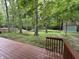 View of the backyard featuring a wooden deck, mature trees, a shed, and a relaxing hammock at 5010 Melbourne Rd, Indianapolis, IN 46228