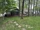 The backyard offers a screened in porch and a relaxing hammock beneath mature trees at 5010 Melbourne Rd, Indianapolis, IN 46228