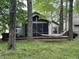 Inviting backyard view featuring mature trees, hammock, and a screened-in porch at 5010 Melbourne Rd, Indianapolis, IN 46228