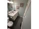 A bathroom showcasing the single sink vanity, grey tile floors and artwork on the walls at 5010 Melbourne Rd, Indianapolis, IN 46228