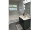 A bathroom featuring a tub, window and single sink vanity with grey hexagon tile floors at 5010 Melbourne Rd, Indianapolis, IN 46228