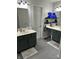 A bathroom showcasing dual sinks, gray hexagon tile floors and storage shelves at 5010 Melbourne Rd, Indianapolis, IN 46228