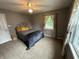 Comfortable bedroom with neutral walls, a ceiling fan, and windows dressed with patterned curtains at 5010 Melbourne Rd, Indianapolis, IN 46228