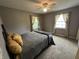 Comfortable bedroom with neutral walls, a ceiling fan, and windows dressed with patterned curtains at 5010 Melbourne Rd, Indianapolis, IN 46228