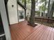 Wooden deck features a built-in planter surrounding a tree, grill, and view of the neighboring houses at 5010 Melbourne Rd, Indianapolis, IN 46228