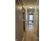 A hallway with neutral walls and flooring leads to a bedroom with a window offering natural light at 5010 Melbourne Rd, Indianapolis, IN 46228