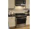 Kitchen featuring a stainless steel gas range, microwave, and subway tile backsplash at 5010 Melbourne Rd, Indianapolis, IN 46228