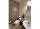 Stylish powder room with floral wallpaper, a sleek white sink, and a modern toilet for added convenience at 5010 Melbourne Rd, Indianapolis, IN 46228