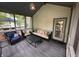 Inviting screened porch featuring comfortable seating, a modern table, and access to the outdoor deck and backyard at 5010 Melbourne Rd, Indianapolis, IN 46228
