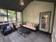 Inviting screened porch featuring comfortable seating, a modern table, and access to the outdoor deck and backyard at 5010 Melbourne Rd, Indianapolis, IN 46228