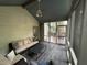 Comfortable screened porch with neutral furniture, gray carpeting, and access to the outdoor deck through a screen door at 5010 Melbourne Rd, Indianapolis, IN 46228