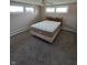 Bedroom featuring neutral walls, cozy carpet, and a comfortable queen-sized bed beneath a ceiling fan at 520 E County Road 500 S, Muncie, IN 47302