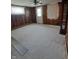 Spacious living room with paneled walls, plush carpet, large windows, and an exterior door at 520 E County Road 500 S, Muncie, IN 47302