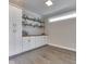 Bright bonus room featuring built-in cabinets, open shelving, hardwood floors, and natural light at 5755 Victory Dr, Columbus, IN 47203