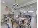 Open-concept dining room featuring hardwood floors, decor, table, chandelier and adjacent to modern kitchen at 5755 Victory Dr, Columbus, IN 47203