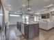 Kitchen island with granite countertops, pendant lighting, stainless appliances, and an open view into the living room at 5755 Victory Dr, Columbus, IN 47203