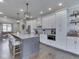 Modern kitchen features white cabinets, granite countertops, stainless steel appliances, and an island with bar seating at 5755 Victory Dr, Columbus, IN 47203