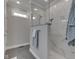 This shower features beautiful white tile, granite countertop, and a seamless glass door at 5755 Victory Dr, Columbus, IN 47203
