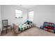 room with windows, a bed with a colorful dinosaur themed cover, chair, and a toy shelf at 5794 Wintersweet Ln, Whitestown, IN 46075