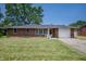 Charming brick home featuring a well-manicured lawn and attached one car garage at 614 Belzer Dr, Anderson, IN 46011