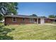 Charming brick home featuring a well-manicured lawn and attached one car garage at 614 Belzer Dr, Anderson, IN 46011