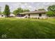 View of the backyard with a home, screened in porch, green lawn, and shed at 6408 Old Mill Dr, Indianapolis, IN 46221