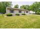 Charming home with a lush front lawn, blue shutters and a fenced in yard to the left at 6408 Old Mill Dr, Indianapolis, IN 46221