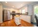 Bright kitchen featuring white cabinets, stainless steel appliances, tile backsplash, and a movable island at 6408 Old Mill Dr, Indianapolis, IN 46221
