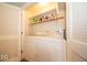 Functional laundry room with a washer, dryer, shelving for storage, and bi-fold closet door at 6408 Old Mill Dr, Indianapolis, IN 46221