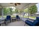 Screened porch features chairs, tables, ceiling fan, and a view of the backyard at 6408 Old Mill Dr, Indianapolis, IN 46221