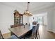 Open dining room with wood table, cabinet with glass doors and modern chandelier at 6524 Turning Leaf Ln, Indianapolis, IN 46236