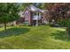 Charming two-story brick home with a well-manicured lawn, lovely landscaping, and mature trees at 6524 Turning Leaf Ln, Indianapolis, IN 46236