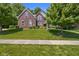 Charming two-story brick home with a well-manicured lawn and mature trees, creating curb appeal at 6524 Turning Leaf Ln, Indianapolis, IN 46236