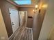 Second-floor hallway featuring updated lighting fixtures, hardwood flooring, and several doorways at , Indianapolis, IN 46227